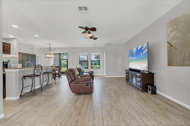 7418 61st St E, Palmetto, FL 34221 - living room featuring visible vents, light wood-type flooring, baseboards, ceiling fan with notable chandelier, and recessed lighting