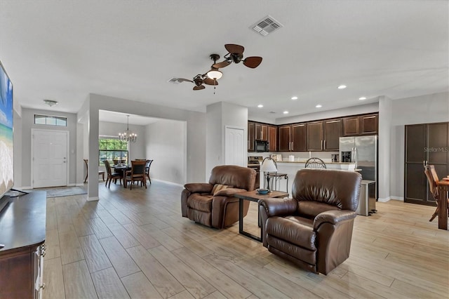 7418 61st St E, Palmetto, FL 34221 - living room with visible vents, light wood-style floors, ceiling fan with notable chandelier, and baseboards
