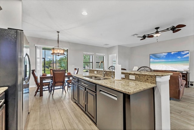 7418 61st St E, Palmetto, FL 34221 - kitchen featuring ceiling fan, hanging light fixtures, appliances with stainless steel finishes, a sink, and light wood-style flooring