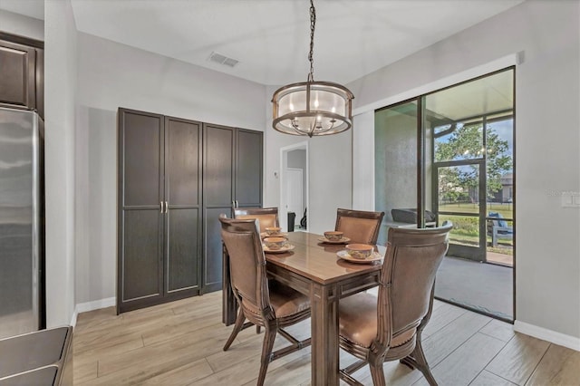 7418 61st St E, Palmetto, FL 34221 - dining area with an inviting chandelier, light wood-style flooring, baseboards, and visible vents