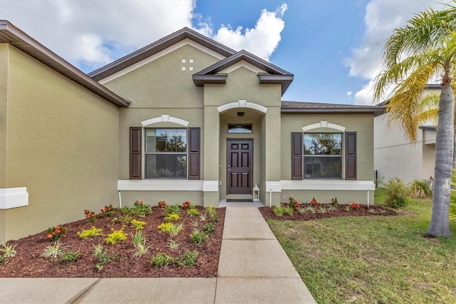 7418 61st St E, Palmetto, FL 34221 - property entrance with a lawn and stucco siding