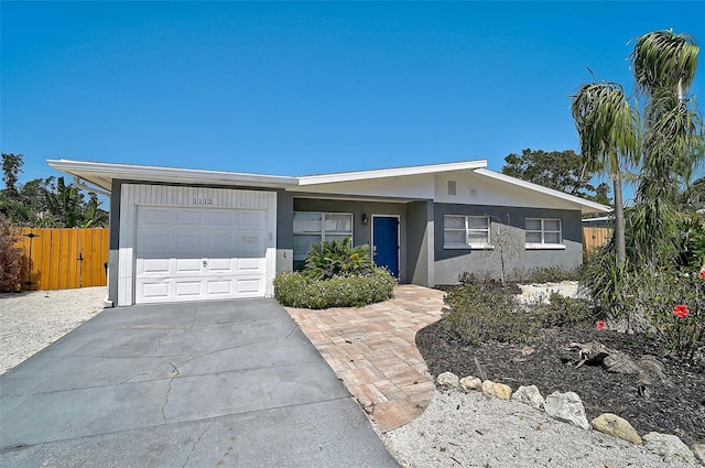 1112 65th St NW, Bradenton, FL 34209 - ranch-style home with fence, an attached garage, concrete driveway, and stucco siding