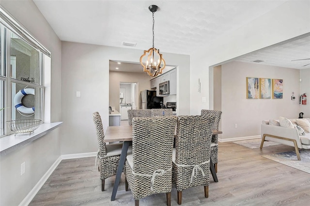 1112 65th St NW, Bradenton, FL 34209 - dining area featuring baseboards, a notable chandelier, visible vents, and light wood-style floors