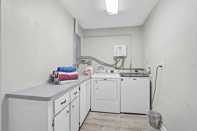 1112 65th St NW, Bradenton, FL 34209 - laundry room featuring light wood-style floors, electric panel, cabinet space, and washer and clothes dryer