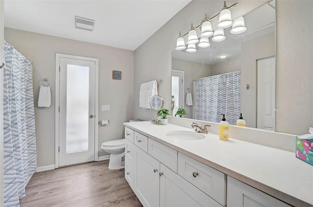 1112 65th St NW, Bradenton, FL 34209 - bathroom featuring visible vents, vanity, wood finished floors, toilet, and a wealth of natural light