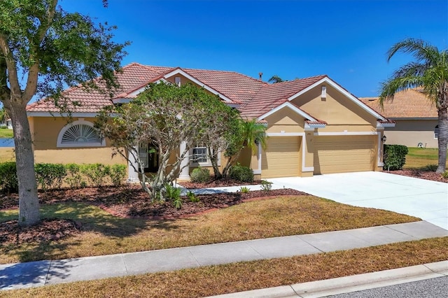 view of front of house featuring a front lawn, stucco siding, a tile roof, and an attached garage
