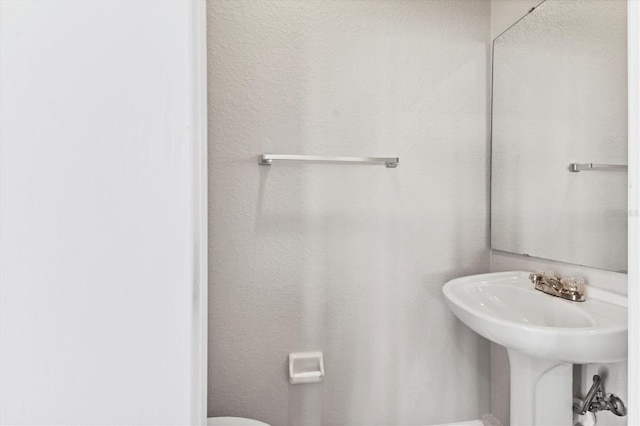 half bathroom with toilet and a sink
