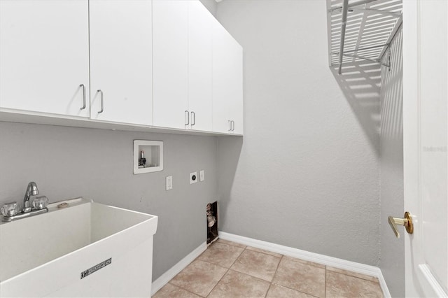 clothes washing area with baseboards, hookup for a washing machine, a sink, cabinet space, and electric dryer hookup