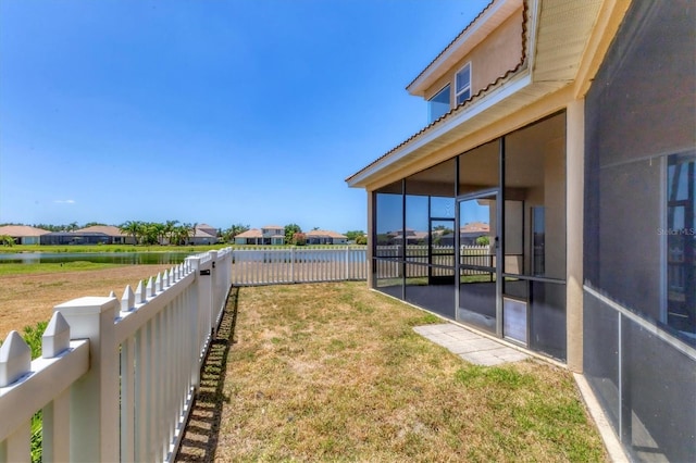 view of yard featuring a sunroom, a residential view, and a fenced backyard