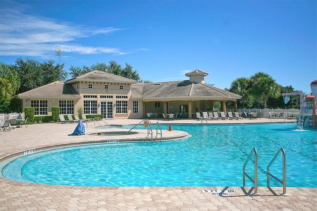 community pool with a patio area, a jacuzzi, and fence
