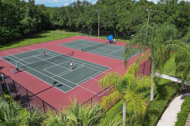 view of sport court with a forest view, fence, and community basketball court