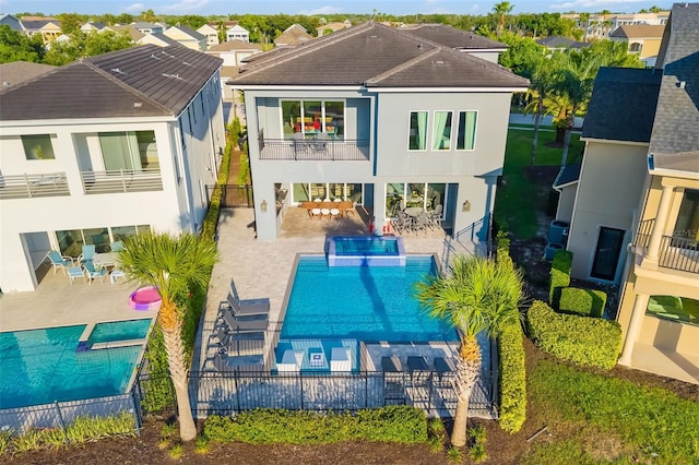 1514 Corolla Ct, Reunion, FL 34747 - rear view of property featuring a balcony, a fenced backyard, stucco siding, and a pool with connected hot tub