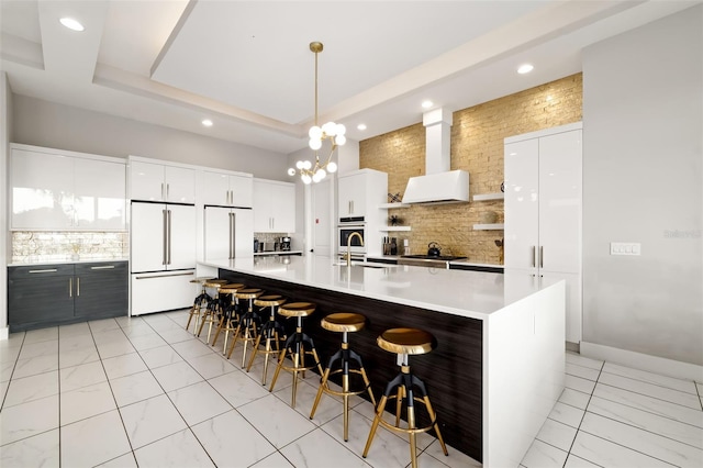 1514 Corolla Ct, Reunion, FL 34747 - kitchen featuring high end white refrigerator, decorative backsplash, wall chimney range hood, modern cabinets, and light countertops