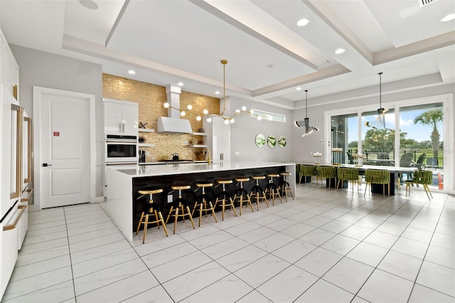 1514 Corolla Ct, Reunion, FL 34747 - kitchen with white appliances, backsplash, a breakfast bar area, light countertops, and white cabinetry