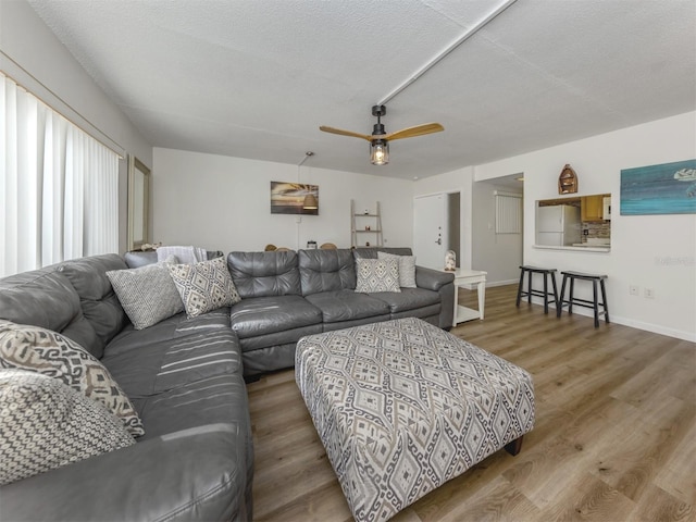 340 Base Ave E Unit 314, Venice, FL 34285 - living room with a ceiling fan, baseboards, wood finished floors, and a textured ceiling