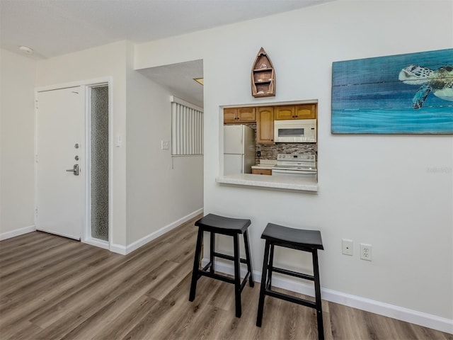 340 Base Ave E Unit 314, Venice, FL 34285 - kitchen featuring light countertops, decorative backsplash, wood finished floors, and white appliances