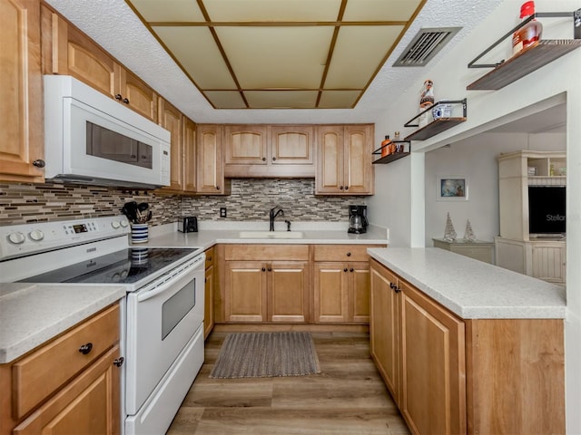 340 Base Ave E Unit 314, Venice, FL 34285 - kitchen featuring white appliances, a sink, light wood finished floors, and tasteful backsplash