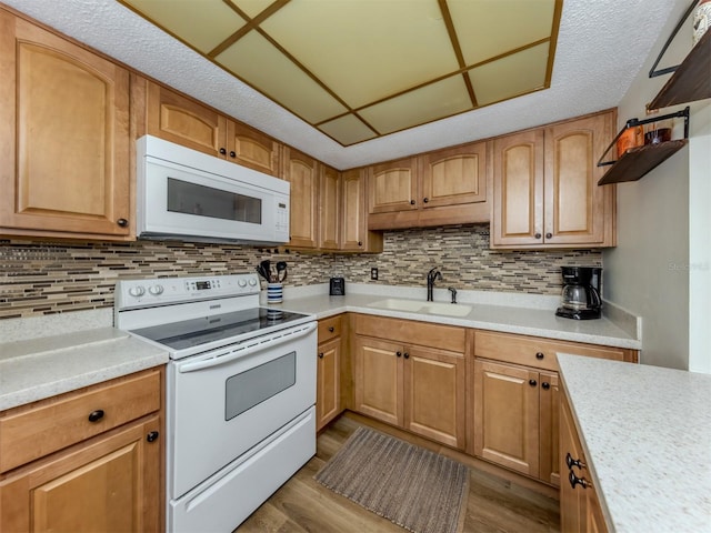 340 Base Ave E Unit 314, Venice, FL 34285 - kitchen with a sink, dark wood-style flooring, white appliances, and light countertops