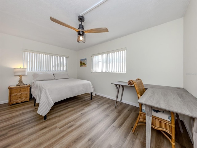 340 Base Ave E Unit 314, Venice, FL 34285 - bedroom featuring baseboards, a ceiling fan, and wood finished floors