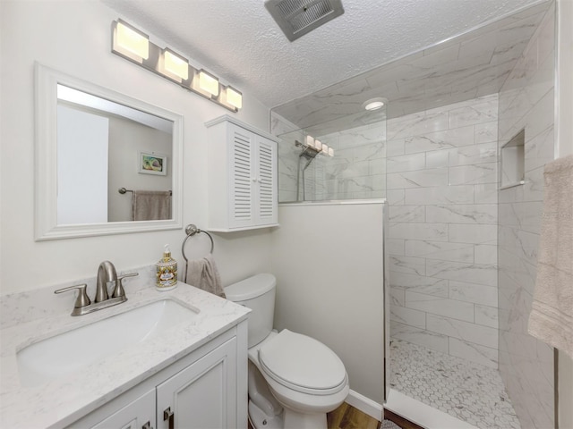 340 Base Ave E Unit 314, Venice, FL 34285 - bathroom with a textured ceiling, visible vents, walk in shower, vanity, and toilet