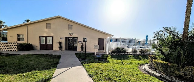 3559 Lake Bayshore Dr Unit J-204, Bradenton, FL 34205 - view of front of home with french doors, fence, stucco siding, and a front yard