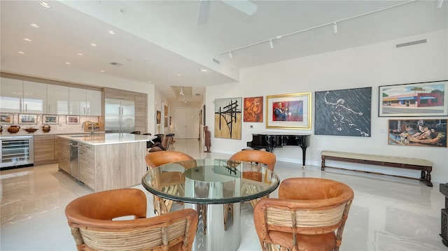 dining space with beverage cooler, rail lighting, recessed lighting, and a ceiling fan