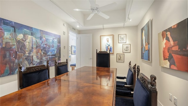 office featuring ceiling fan, a tray ceiling, and baseboards