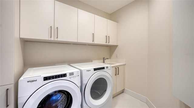 laundry room with washing machine and clothes dryer, cabinet space, and baseboards