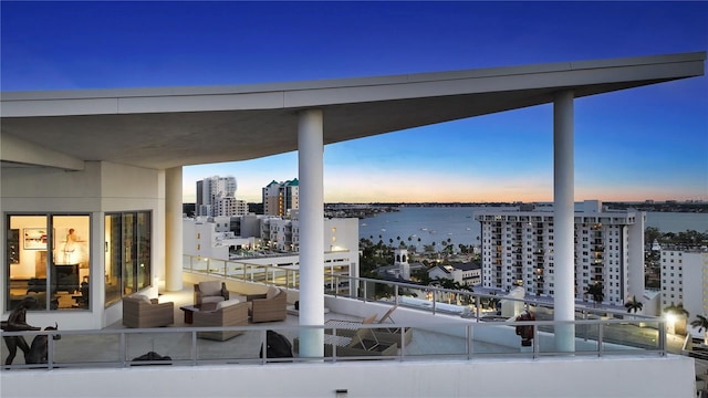 view of patio / terrace with a water view, a balcony, a city view, and an outdoor living space