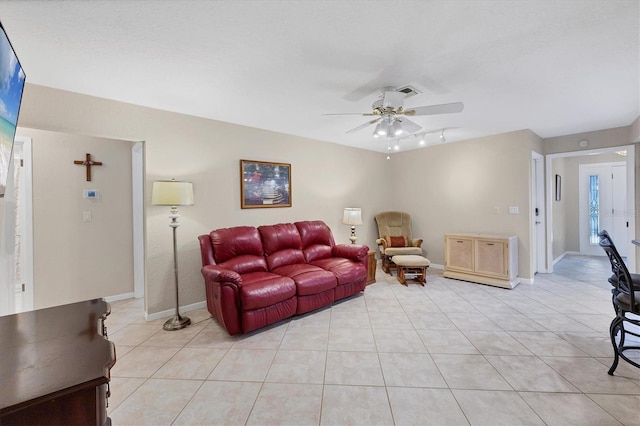 living room with a ceiling fan, light tile patterned floors, and baseboards