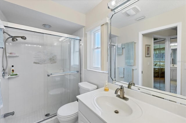 bathroom featuring toilet, a stall shower, and vanity