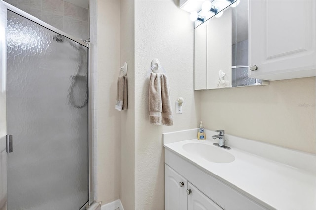 bathroom with a shower stall and vanity