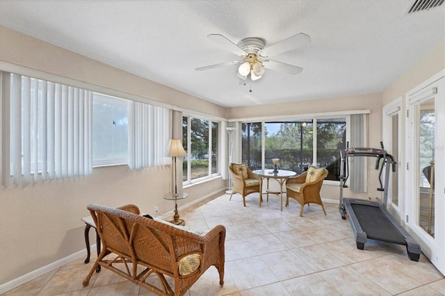 sunroom featuring plenty of natural light, baseboards, and tile patterned flooring