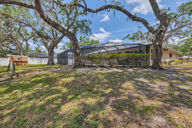 view of green lawn featuring a lanai