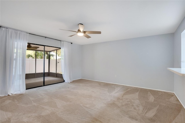 empty room featuring carpet floors, a ceiling fan, and baseboards