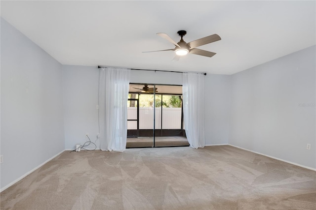 carpeted empty room with baseboards and a ceiling fan