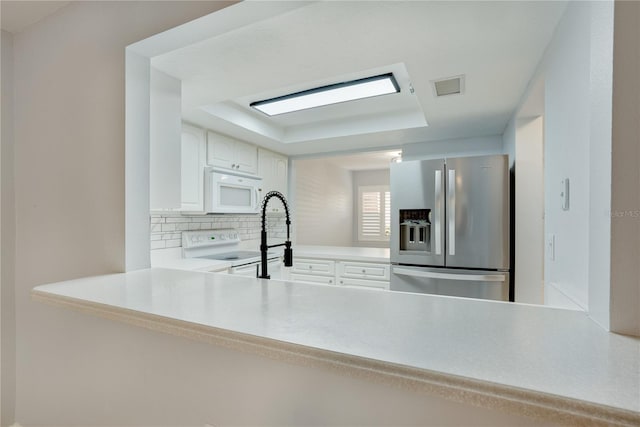 kitchen featuring visible vents, decorative backsplash, white appliances, light countertops, and white cabinets
