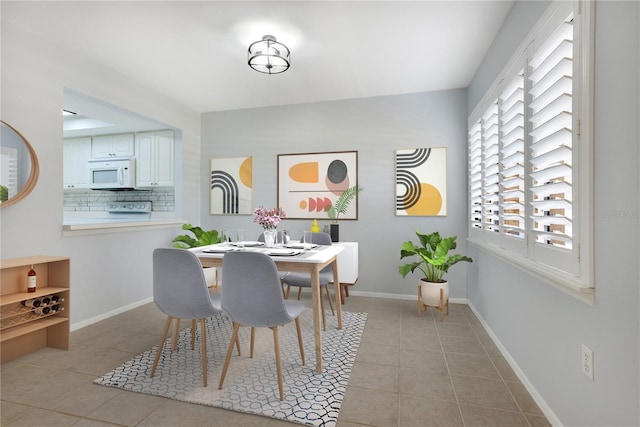 dining room featuring baseboards and light tile patterned flooring