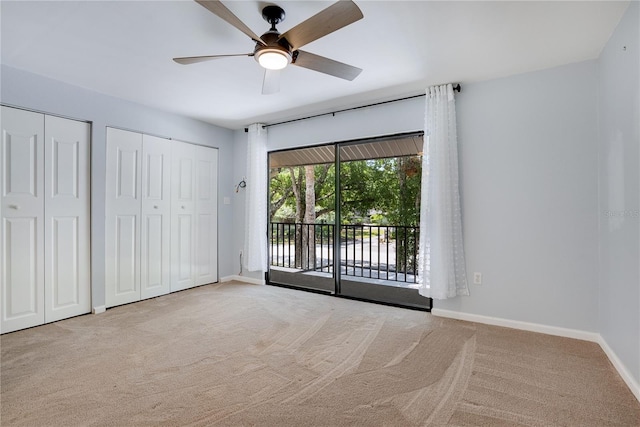 unfurnished bedroom featuring a ceiling fan, access to exterior, baseboards, multiple closets, and carpet flooring