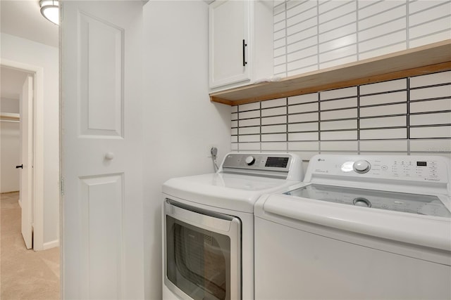 laundry room featuring light carpet, cabinet space, and washer and dryer