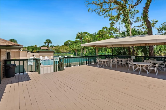 deck with a community pool and outdoor dining space