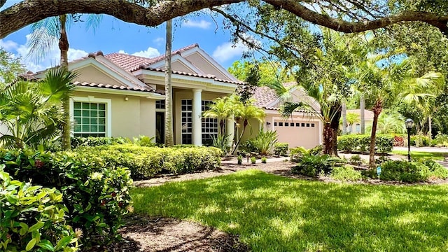 6924 Cumberland Ter, University Park, FL 34201 - mediterranean / spanish-style home with a tiled roof, stucco siding, an attached garage, and a front yard