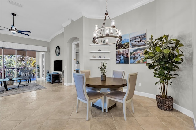 dining space with light tile patterned flooring, arched walkways, ceiling fan with notable chandelier, baseboards, and ornamental molding