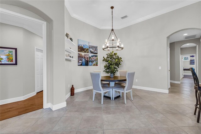 dining room with light tile patterned flooring, a notable chandelier, arched walkways, baseboards, and visible vents