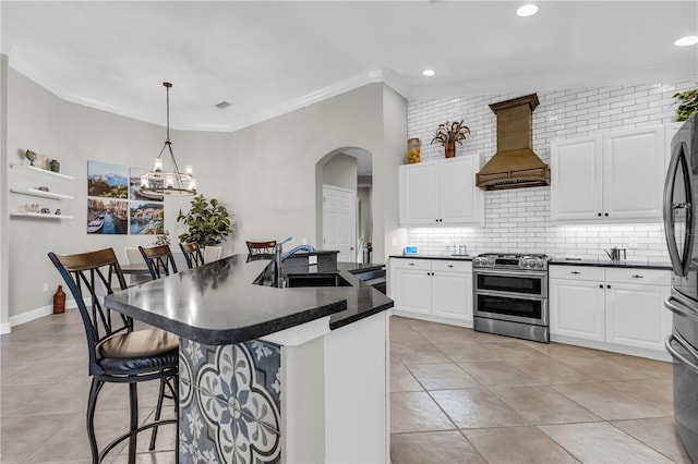kitchen with a sink, premium range hood, dark countertops, and range with two ovens
