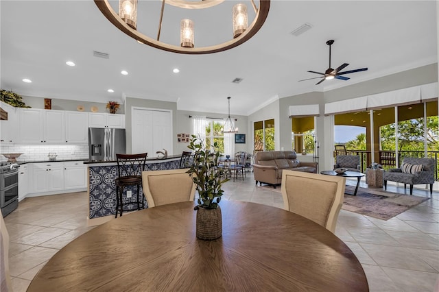 dining space with crown molding, light tile patterned floors, ceiling fan with notable chandelier, and recessed lighting
