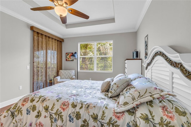 bedroom featuring a ceiling fan, baseboards, ornamental molding, and a raised ceiling