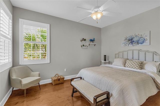 bedroom with baseboards, ceiling fan, and wood finished floors