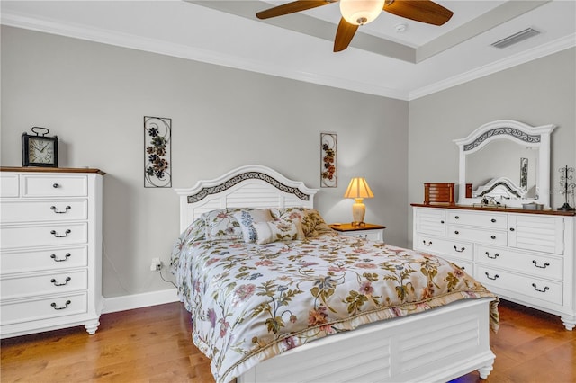 bedroom with crown molding, visible vents, and hardwood / wood-style floors