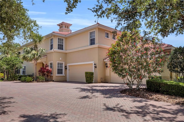 view of front facade with decorative driveway, a garage, and stucco siding